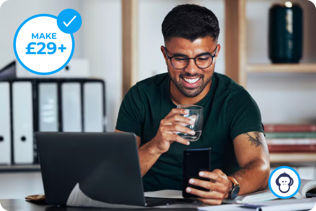 Man smiling at his phone next to a laptop, with a MAKE £29+ badge